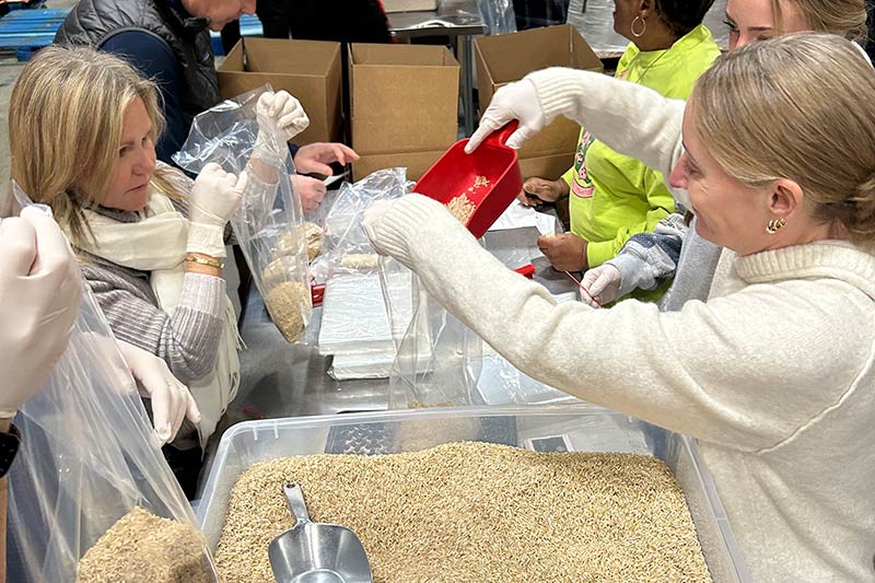 2 blonde female Maryland Food Bank volunteers repackage bulk rice during Martin Luther King, Jr. Day of Service event